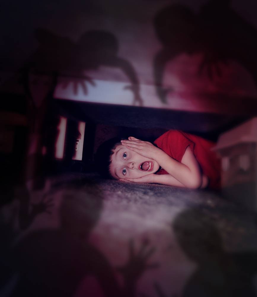 Человек заглядывает под кровать